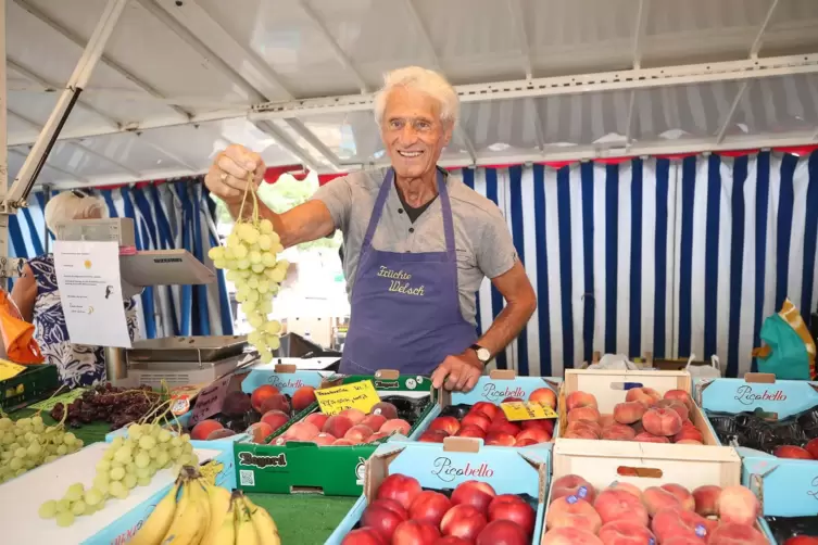 Ein letztes Mal noch für den Fotografen: Rudi Adam mit Schürze hinter dem Marktstand.