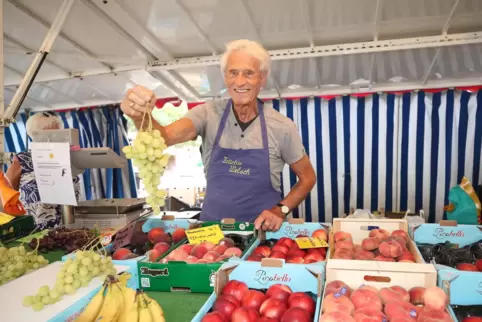 Ein letztes Mal noch für den Fotografen: Rudi Adam mit Schürze hinter dem Marktstand.