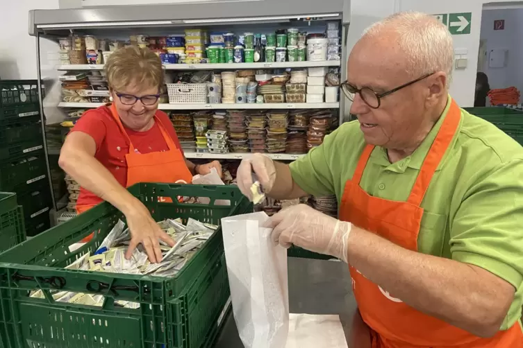 Heidi Kaufmann und Albert Stoller beim Verpacken: Kleinstwaren wie Mayo-Päckchen werden in kleinen Papiertüten ausgegeben. 