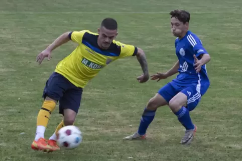 Marcel Weiß (links) von der SG Rockenhausen/Dörnbach spielt den Ball, Christian Brill vom VfR Kaiserslautern kommt hier zu spät.