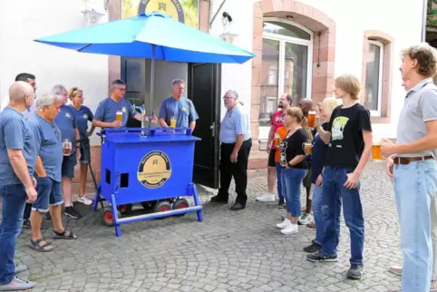 Thomas Claren (hinter der Zapfanlage) erklärt Besuchern am Samstag den Bollerwagen Marke Eigenbau und gibt Auskünfte zur Tour. 