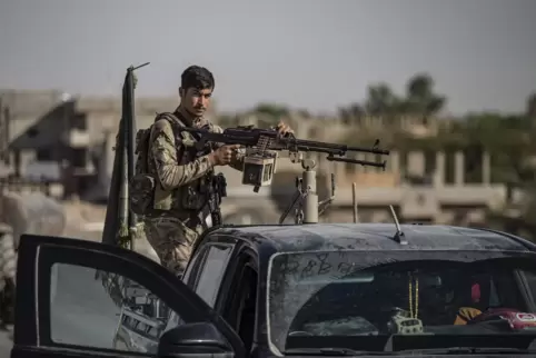 Ein von den USA unterstützter Kämpfer der Syrischen Demokratischen Kräfte (SDF) auf einem gepanzerten Fahrzeug in Ostsyrien. 