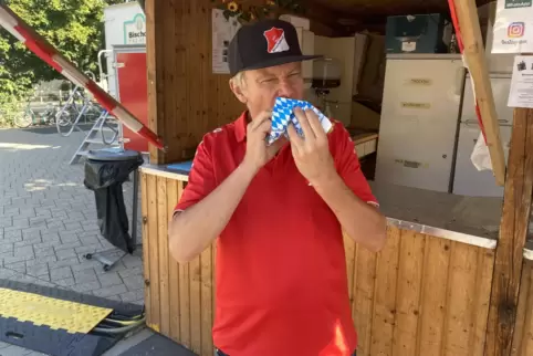 Zum Kerwebesuch gehört auch die Bratwurst: Helmut Marnet vor dem Stand des ASV Birkenheide. „Die Kerwe hat Zukunft“, ist er über