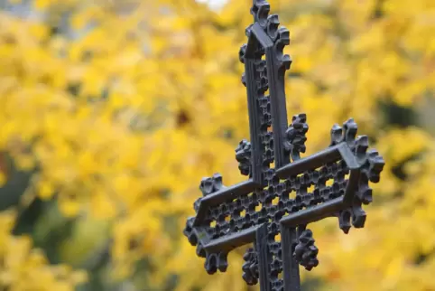 Ein eisernes Kreuz steht auf einem Friedhof