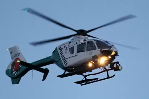 Ein Polizeihubschrauber mit eingeschalteten Scheinwerfern