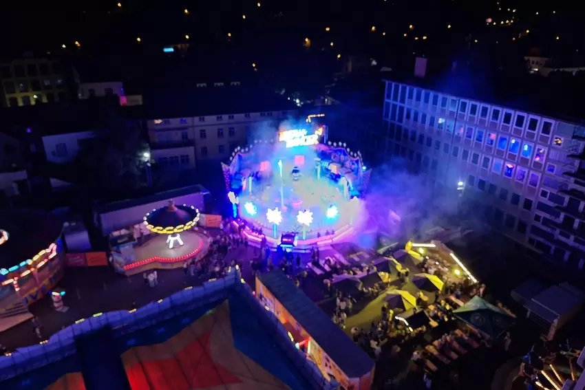 Welch ein Anblick: der Messeplatz bei Dunkelheit aus der Vogelperspektive mit dem Breakdancer im Nebel.