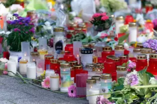 Solingen: Blumen und Kerzen in Gedenken an die Opfer liegen an einer Kirche in der Nähe des Tatorts.