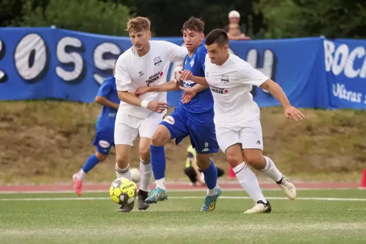 Jona Wildberger (links) und Marcel Korb (rechts) von der TSG Wolfstein-Roßbach stoppen Angreifer Silas Gutmann vom FK Pirmasens.