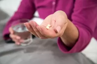 Frau mit Tabletten in der Hand