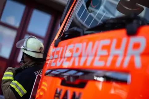 Feuerwehrmann steht neben einem Feuerwehrauto.