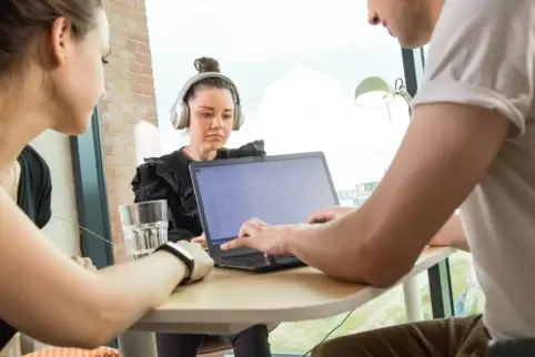 Frau mit Kopfhörern im Büro