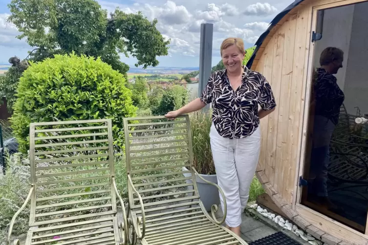 Gastgeberin Kerstin Opitz auf der Terrasse des Ferienlofts. Rechts die Fass-Sauna.