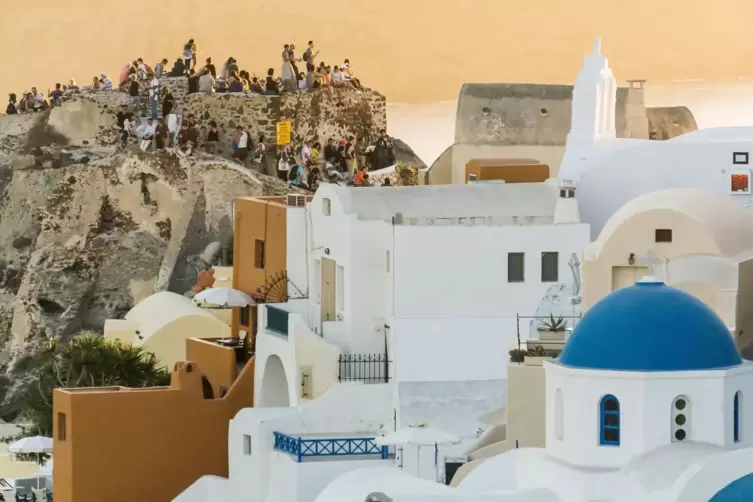 Touristen auf Santorin bei Sonnenuntergang