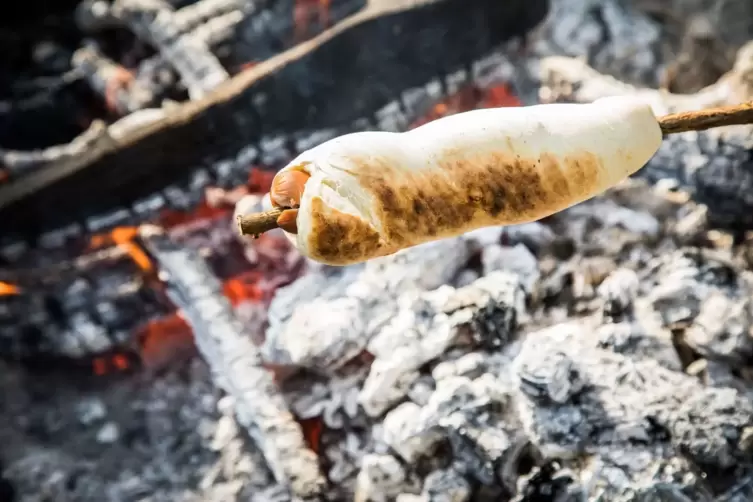 Stockbrot mit Wüstchen im Teig als Hot Dog