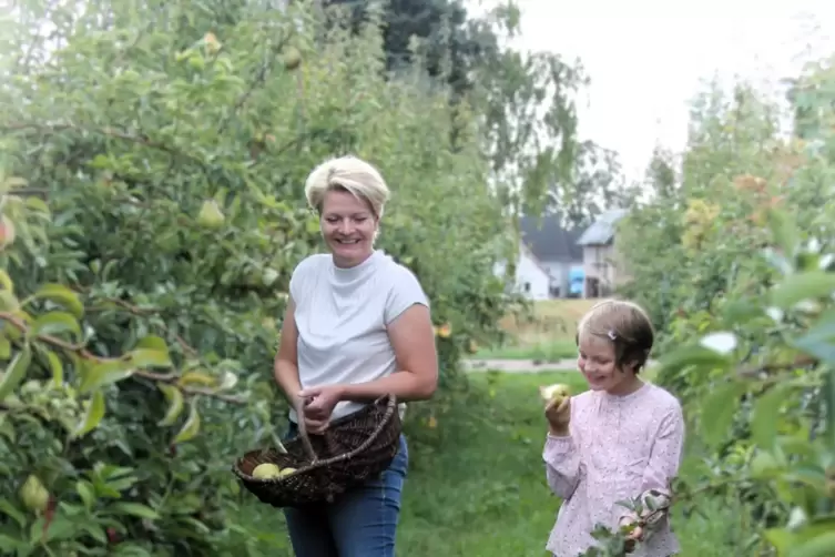 Esther Grün mit ihren Kindern Emily und Lilly beim Birnenpflücken. Auch Hund „Sunny“ ist dabei.