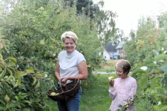 Esther Grün mit ihren Kindern Emily und Lilly beim Birnenpflücken. Auch Hund »Sunny« ist dabei.