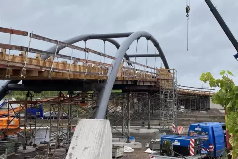 An der neuen Rad- und Fußgängerbrücke über die B10 wird die Schalung abgebaut. 