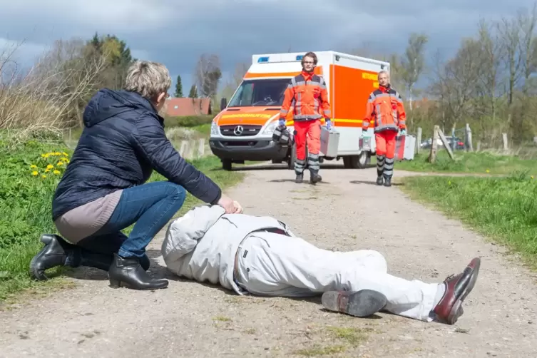 Eine Frau wartet auf einen Rettungswagen