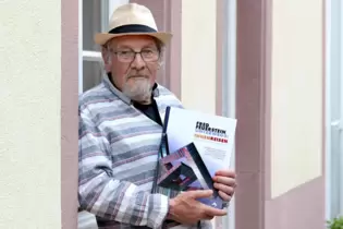 Fred Feuerstein an seinem 76. Geburtstag vor seinem Atelier im Kulturhof mit dem ihm und seinem Schaffen gewidmeten Buch "Fred F