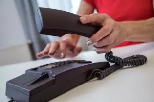 Eine Frau benutzt ein Festnetztelefon