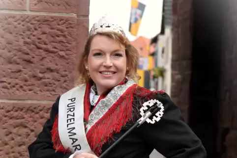 Purzelmarktkönigin Corinna Boos in Tracht am Billigheimer Tor. Im Hintergrund die Fahnen des Ortes zu sehen.