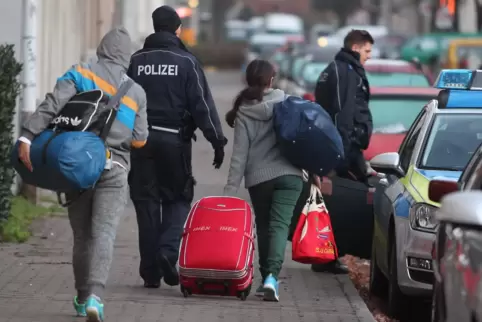 Zwei abgelehnte Asylbewerberinnen werden von Polizeibeamten bei der Abschiebung begleitet. 