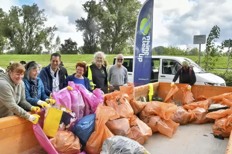 Einige Helfer des „Rhinecleanup“ mit ihrer „Beute“: einem rosa Gummiboot.