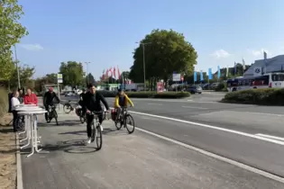 Baudezernent Manuel Steinbrenner und Radverkehrsbeauftragte Julia Bingeser rollen auf dem ausgebauten Radweg den Kollegen voraus