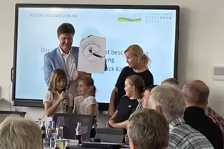 Ein fliegender Storch: Bürgermeister Harald Westrich zeigt den Entwurf des Logos. Die Kinder berichten mit Schulleiterin Sabine