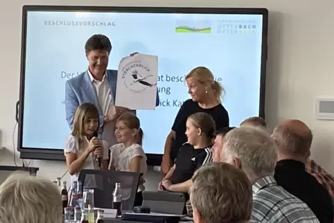 Ein fliegender Storch: Bürgermeister Harald Westrich zeigt den Entwurf des Logos. Die Kinder berichten mit Schulleiterin Sabine 