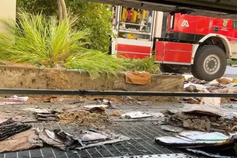 Gelöschtes Brandmaterial vor dem Kellerfenster.