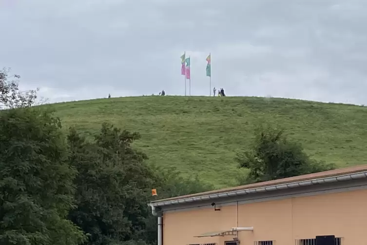 Fahnen und erste Besucher auf dem Deponiehügel.