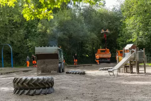 Mitarbeiter des Baubetriebshofs bringen neuen Kies in das Becken des Wasserspielplatzes beim Jägersburger Weiher. Bis dort wiede