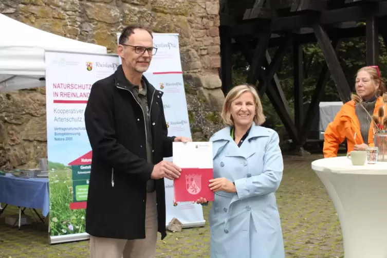 Klimaschutzministerin Katrin Eder (rechts) übergibt den Förderbescheid an Pollichia-Präsident Michael Ochse.