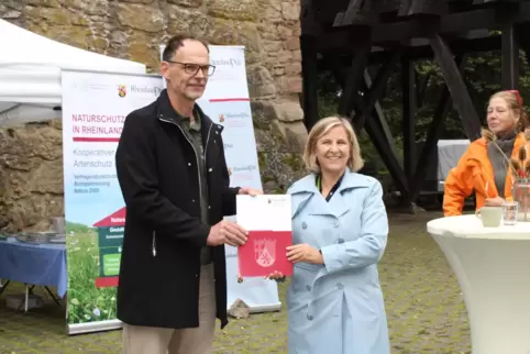 Klimaschutzministerin Katrin Eder (rechts) übergibt den Förderbescheid an Pollichia-Präsident Michael Ochse.