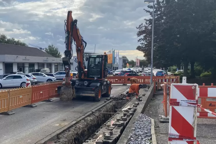 Während am Straßenrand gearbeitet wird, staut sich der Baustellenampel der Verkehr: Kirchheimer Straße in Grünstadt. 