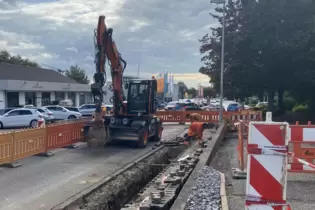 Während am Straßenrand gearbeitet wird, staut sich der Baustellenampel der Verkehr: Kirchheimer Straße in Grünstadt.