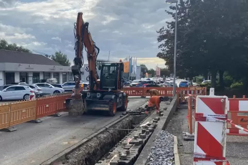 Während am Straßenrand gearbeitet wird, staut sich der Baustellenampel der Verkehr: Kirchheimer Straße in Grünstadt. 