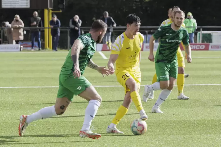 Der Morlauterer Thomas Roetynck (in Gelb) behauptet hier den Ball vor Christian Meinert vom FV Engers.