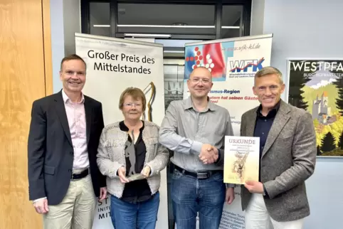 Landrat Ralf Leßmeister (rechts) überreicht gemeinsam mit dem Geschäftsführer der Wirtschaftsförderungsgesellschaft Stadt und La