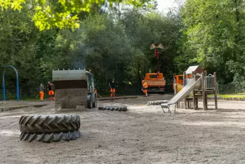 Mitarbeiter des Baubetriebshofs bringen neuen Kies in das Becken des Wasserspielplatzes. 