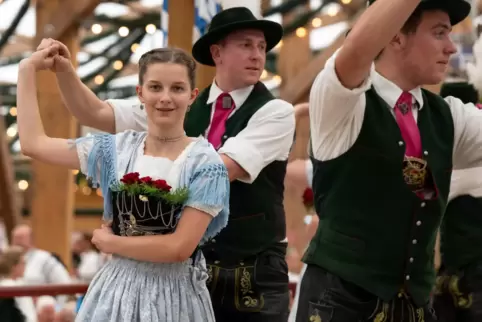 Teilnehmer des Trachten- und Schützenzugs feiern nach dem Umzug auf dem Oktoberfest in einem Festzelt. 