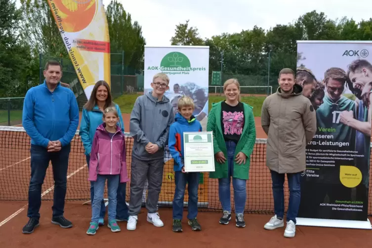 Daniela Hock und Dennis Stortz von der AOK (rechts) überreichen dem Vorsitzenden des TC Göllheim, Wolfgang Stark (links), sowie 