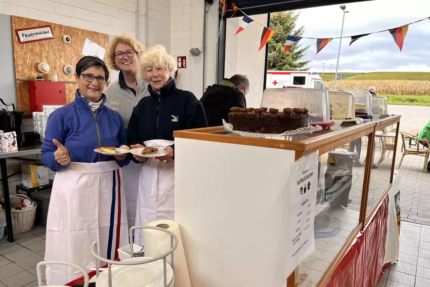 Die Gruppe rund um die Partnerschaft Obrigheim-Cŕevecoeur le Grand verkauft Kuchen.