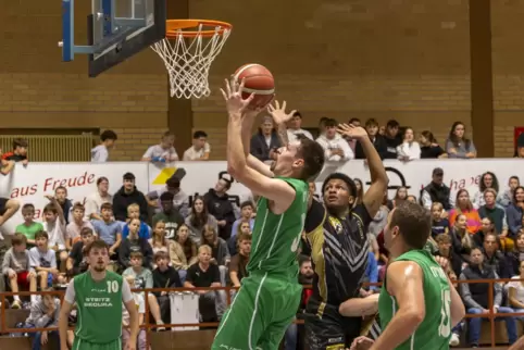  Tom Dreyer (mit Ball) vom TV Kirchheimbolanden zieht zum Korb, Adam Pollard von den Fastbreakers (in schwarz) kann ihn nicht me