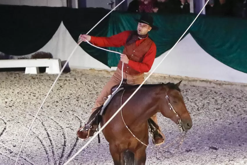 Cowboy Michal Konecný galoppiert innerhalb der von ihm geschwungenen riesigen Lassoschlaufe.