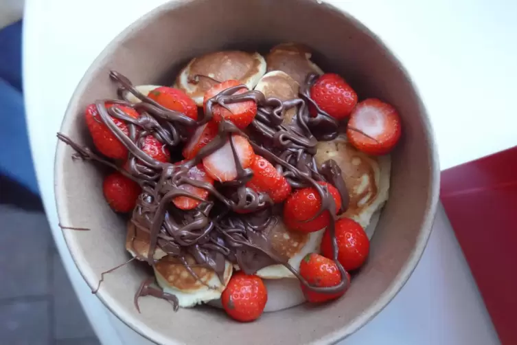 Ein Dessert sind Pancakes mit Nutella und Erdbeeren.