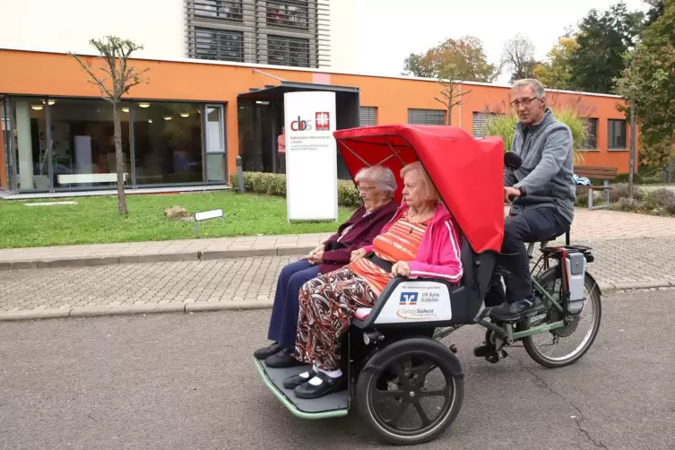 Peter Knaak fährt die Bewohnerinnen Gisela Benzinger und Brigitte Kondziella mit der Rikscha. 