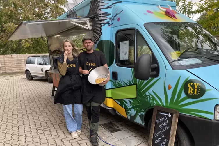 Cyril Maximilian Schmidt und seine Lebensgefährtin Anna Sophie Schlocker vor dem Foodtruck, der sich genauso bunt präsentiere wi