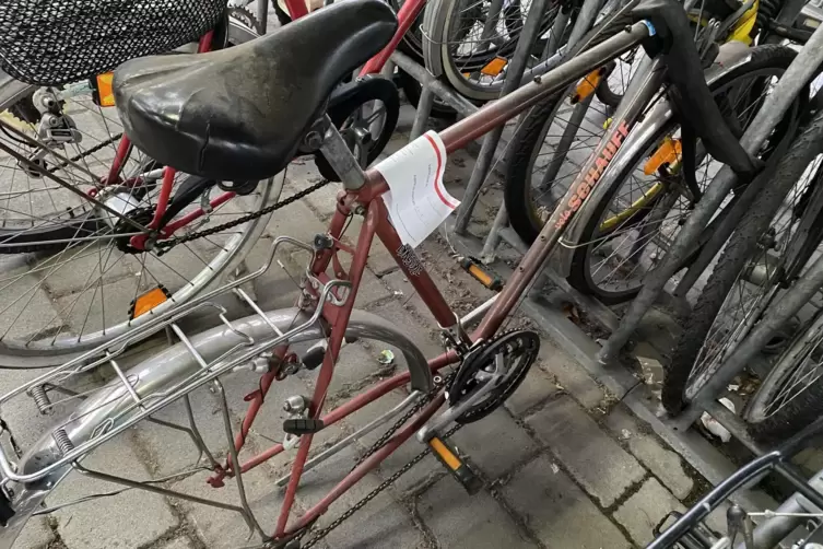 Fahrradleichen in der Radabstellanlage am Hauptbahnhof mit Hinweiszettel auf die Entfernung der Bahn.